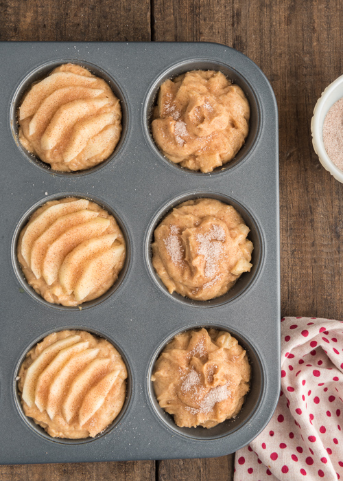 Batter, with apple slices and cinnamon in the muffin tin.