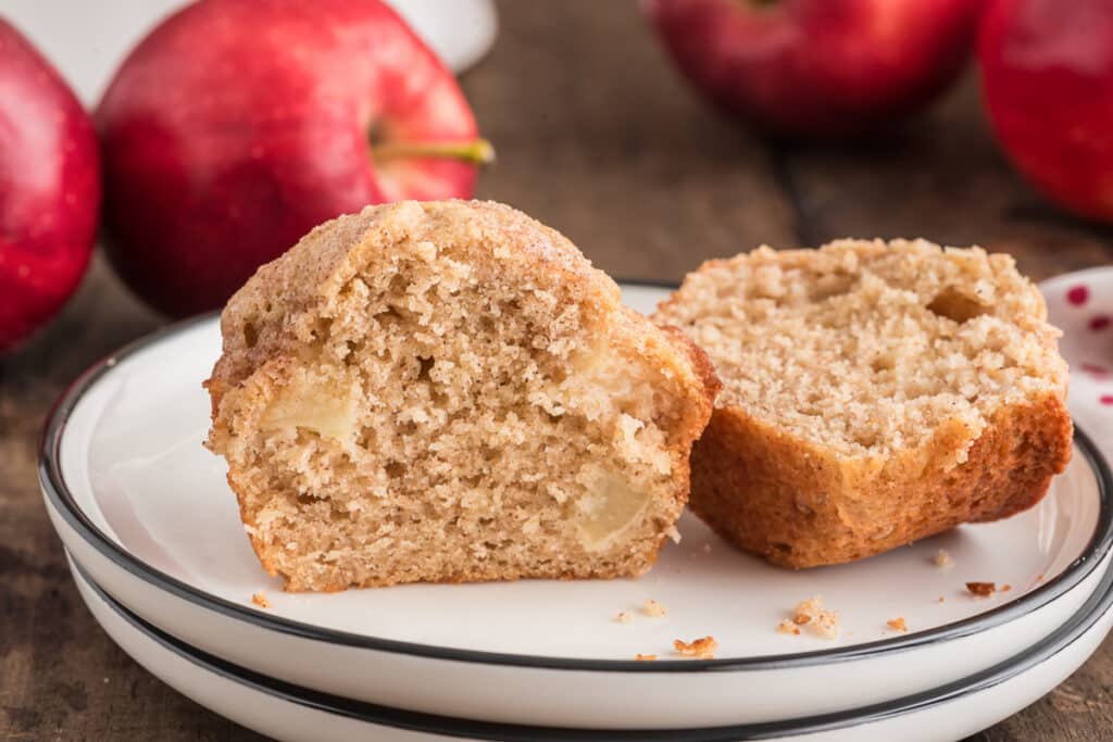 A muffin cut in half on a white plate.