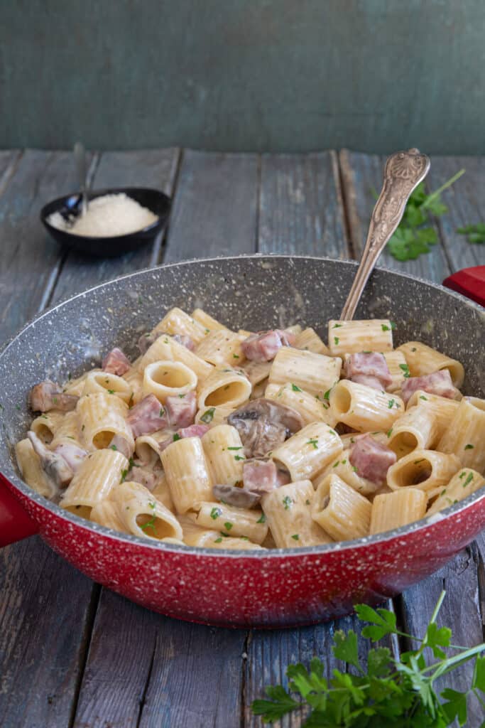 Mushroom pasta in a red pan.