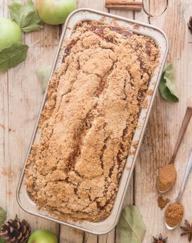 applesauce bread on a wooden board with apples and spices