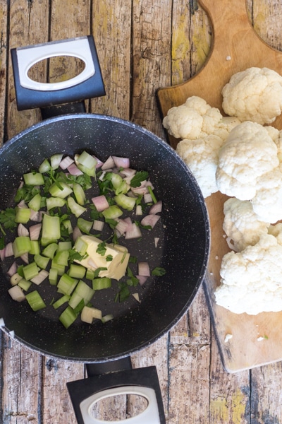 sauteeing the shallot & celery in butter with the cauliflower florets on a wooden board