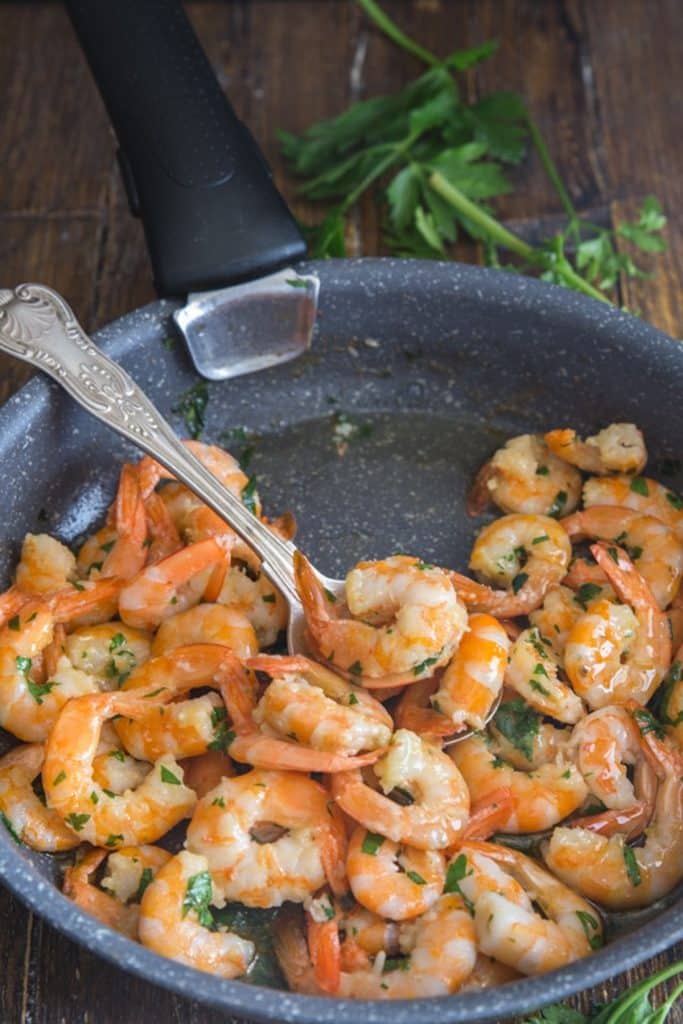 Sauteed shrimp in a black pan.