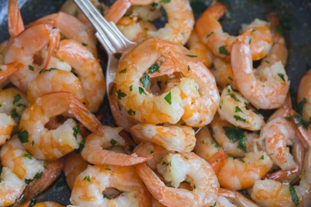 Shrimp on a spoon and in the pan.