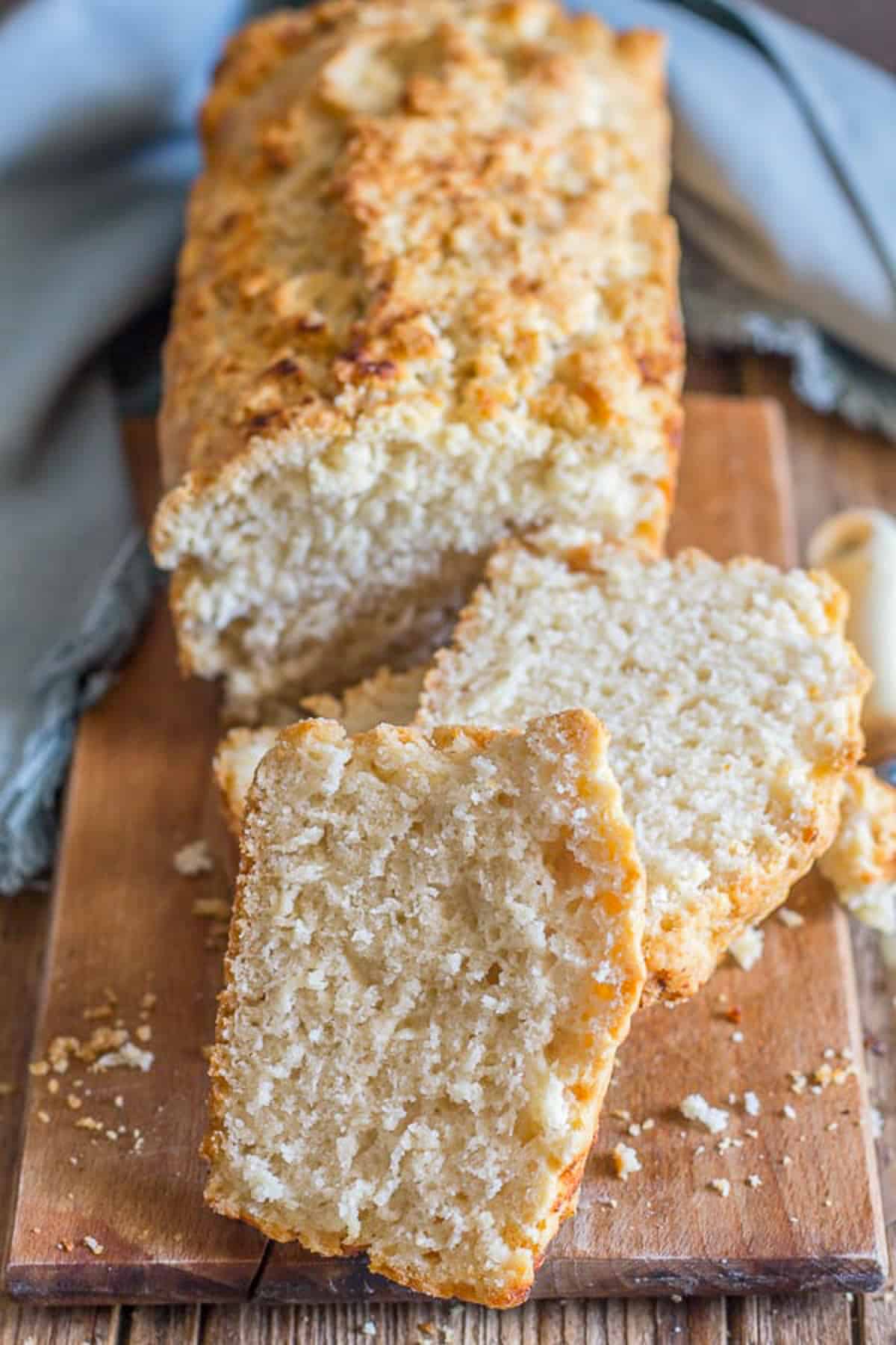 Beer bread with two slices cut on a wooden board.