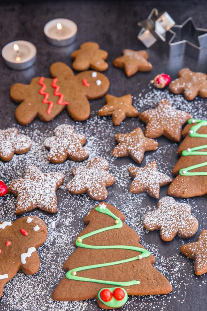 Decorated gingerbread cookies on a black board.