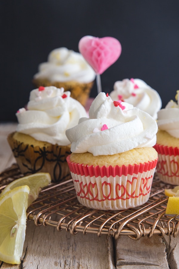 lemon cupcakes on a gold cake rack with a pink heart on a stick