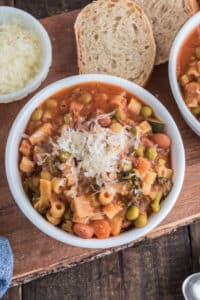 Minestrone in a white bowl with cheese.
