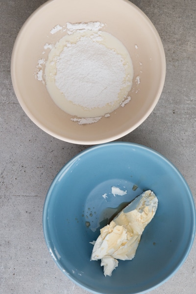 cream and sugar in a white bowl and mascarpone and vanilla in a blue bowl