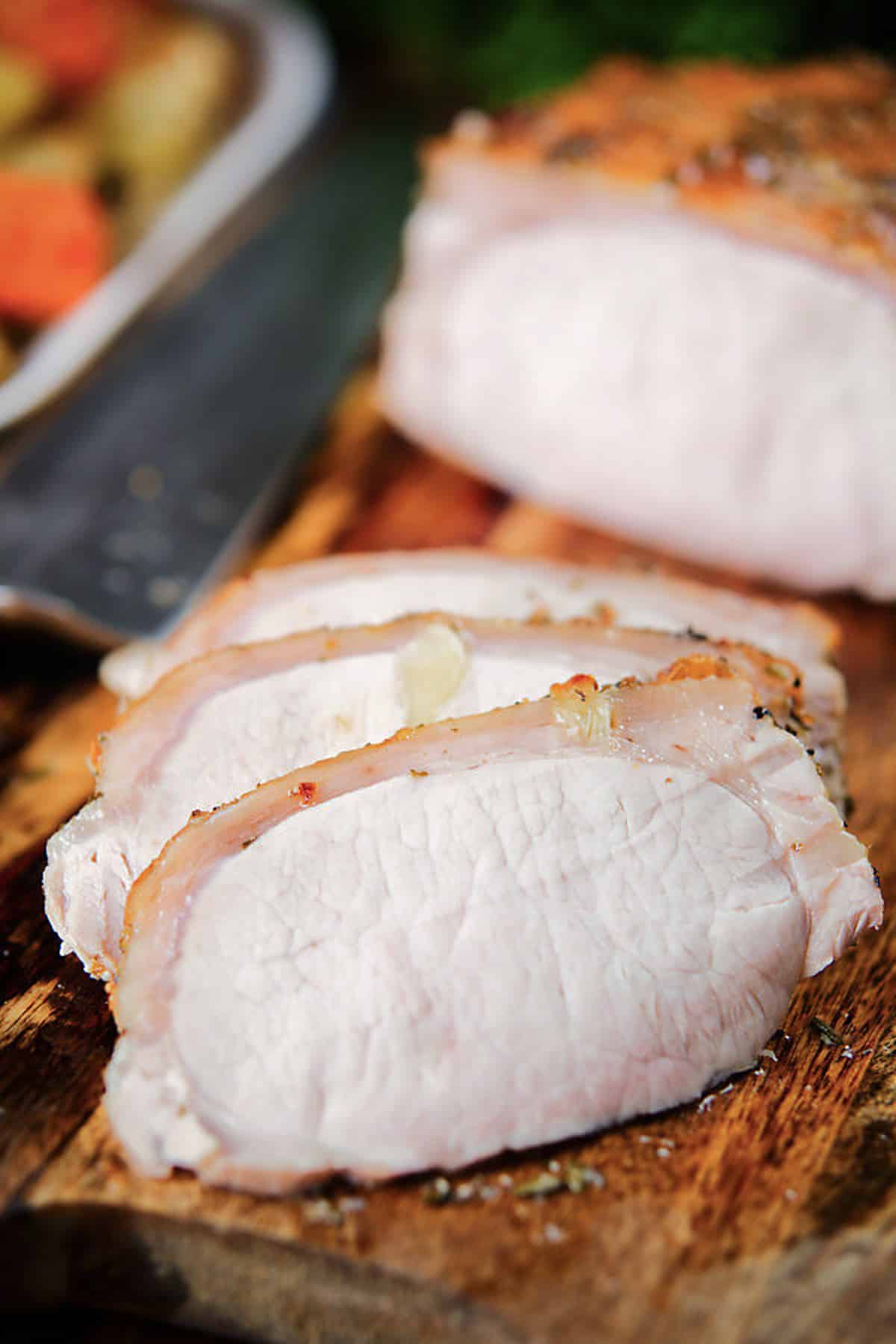 Pork tenderloin with three slices cut.