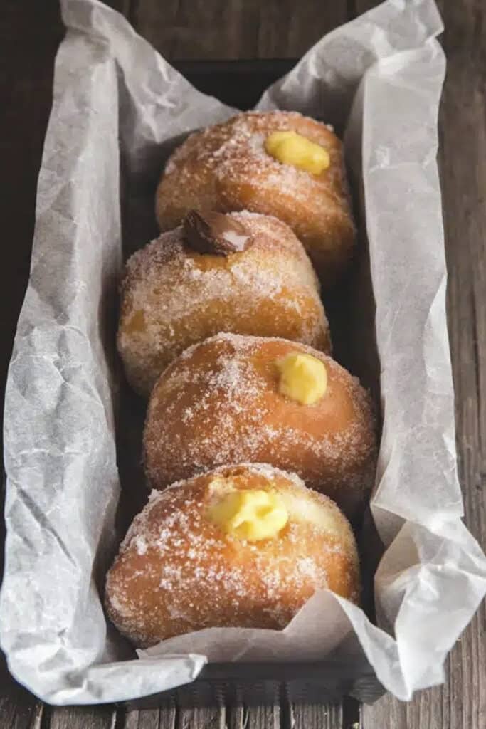 Four bomboloni donuts in a loaf pan.