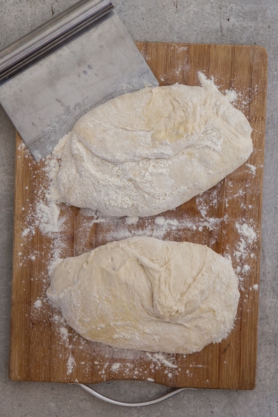 dividing the dough into two parts on a wooden board