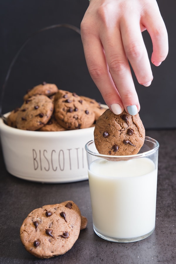 dunking a cookie into a glass of milk