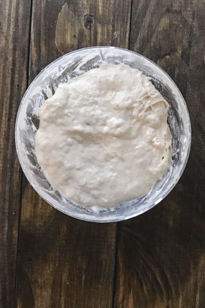 flour and water mixed into the starter in a glass bowl