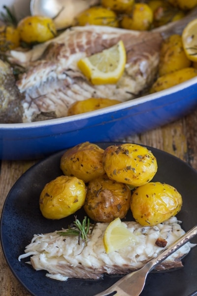 Baked whole trout in a pan and some on a black plate.