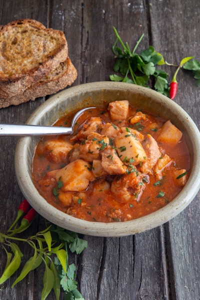 Fish soup in a grey bowl.