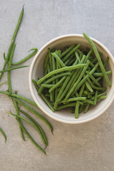 trimmed green beans in a white bowl