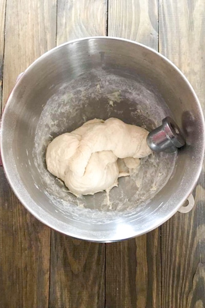 adding the flour and kneading the dough in the mixing bowl
