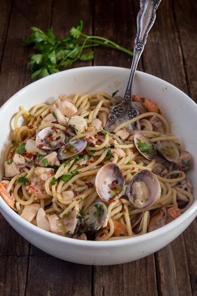 Seafood pasta in a white bowl.