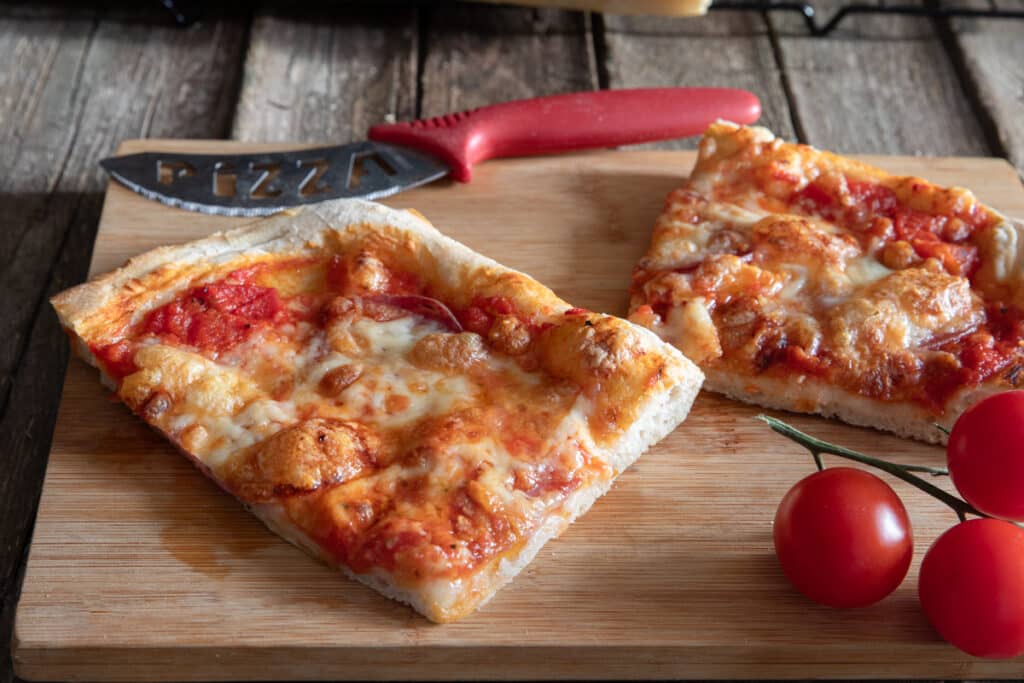 Two slices of pizza on a board.