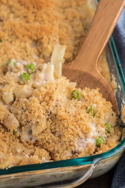 Tuna casserole in a glass pan with some on a spoon.