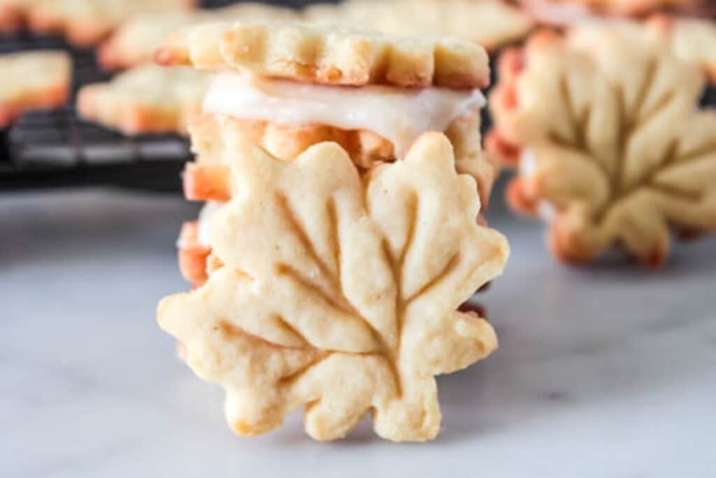 Sandwich cookies stacked with one leaning on them.