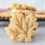 Sandwich cookies stacked with one leaning on them.