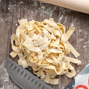 2 ingredient pasta on a wooden board with a knife.