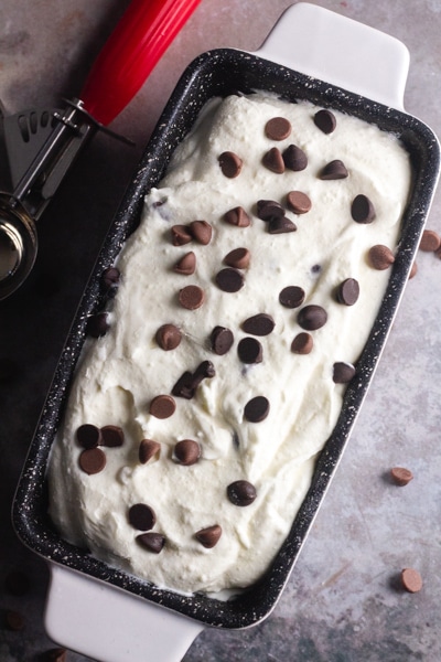 frozen ice cream with chocolate chips on top in a white loaf pan
