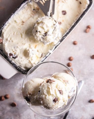 ice cream in the loaf pan with a scoop and 3 scoops in a tall glass dish