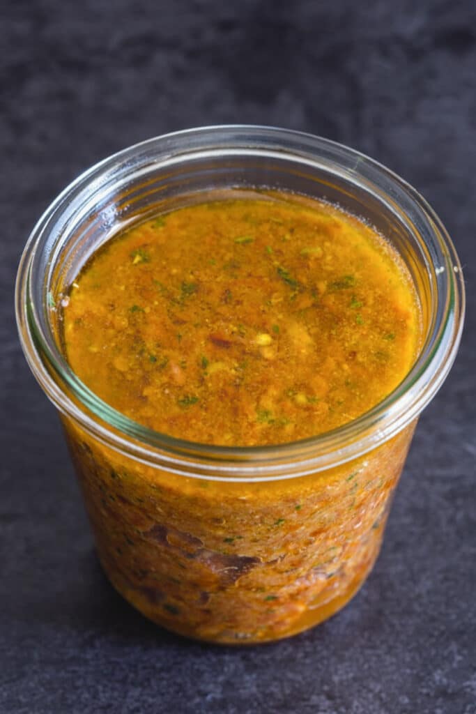 Sun-dried tomato pesto in a glass jar covered with oil.