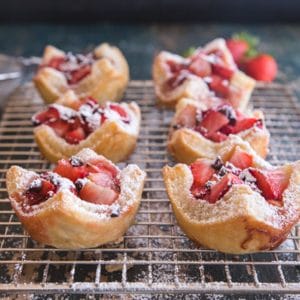 strawberry tarts sprinkled with powdered sugar on a wire rack