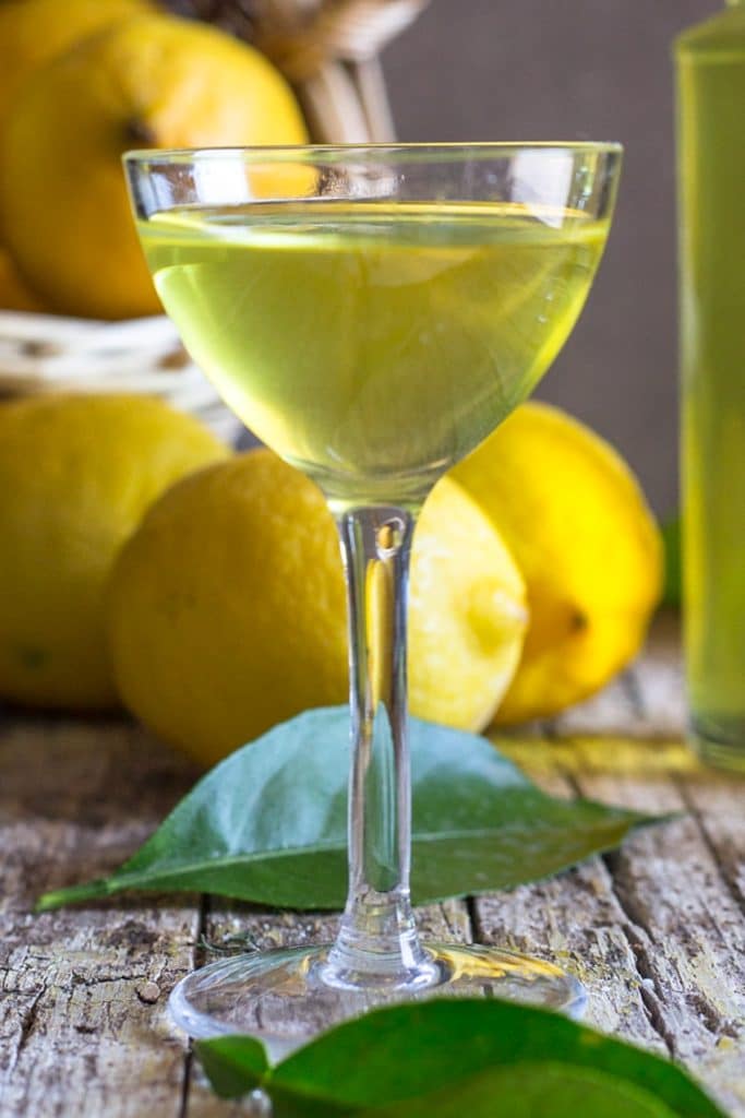 A glass of liqueur with lemons.