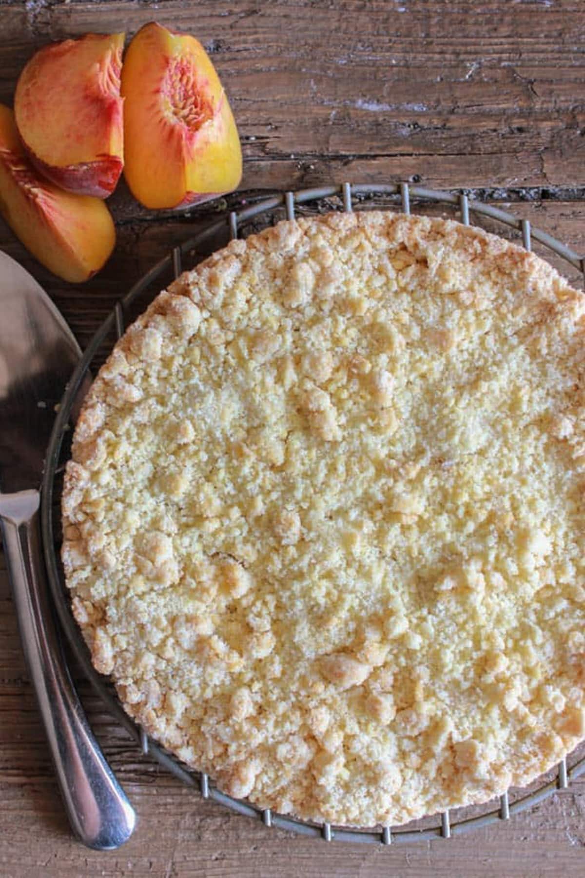 Peach crumb cake on a wire rack.