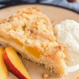 A slice of crumb cake on a cream plate.