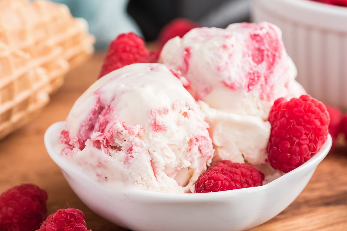 Two scoops of ice cream in a white bowl.