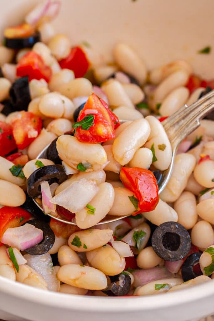 Bean salad in the white bowl.
