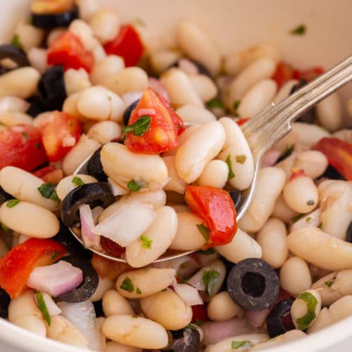 bean salad in a white bowl with a spoonful