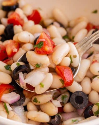 bean salad in a white bowl with a spoonful