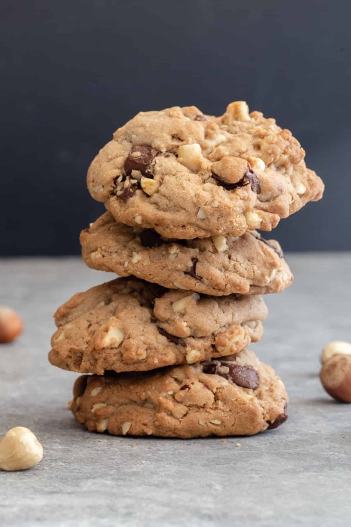 Four stacked cookies on a grey board.