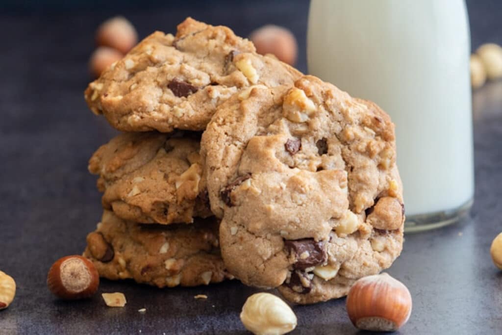 Three cookies stacked and one leaning against it.