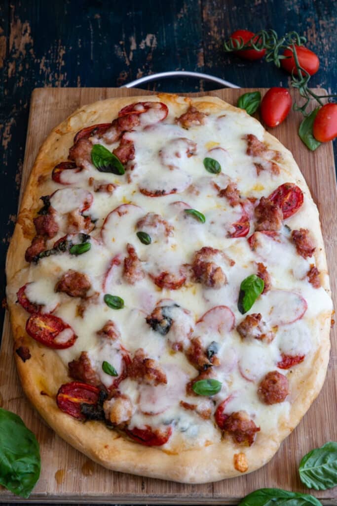 Fresh tomato pizza on a wooden board.