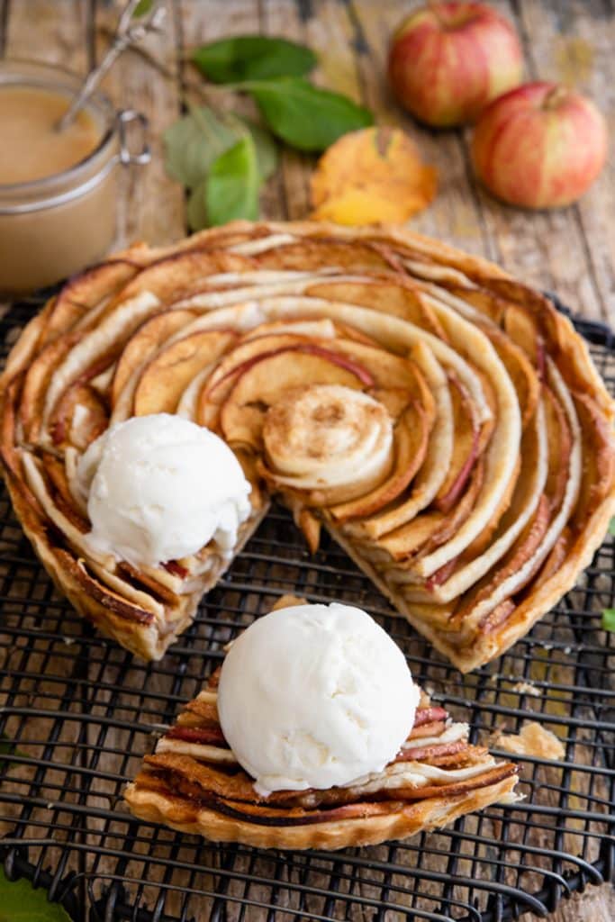 Apple pie with a slice cut and two scoops of ice cream.
