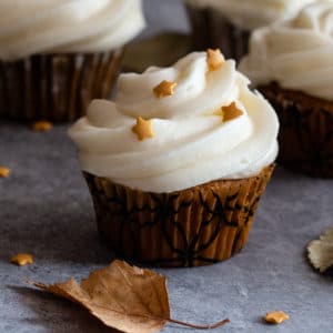 pumpkin cupcake with a leave on a grey board