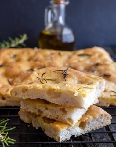 3 slices of focaccia on top of each other with remaining on a wire rack