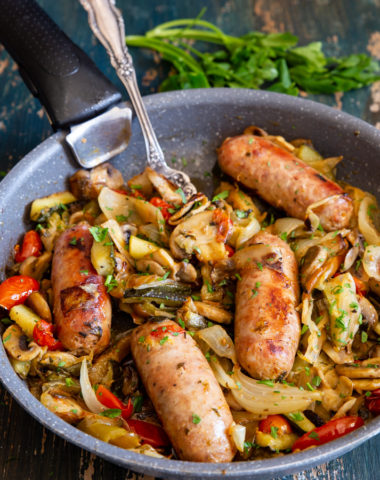 sausages and vegetables in a black pan