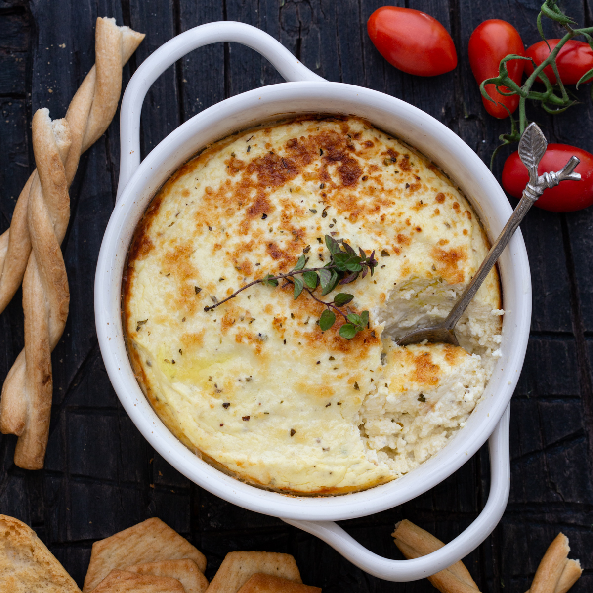 baked ricotta in a white baking dish with a spoon