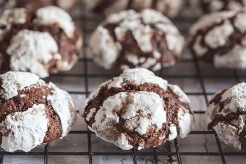 Chocolate crinkle cookies on a wire rack.