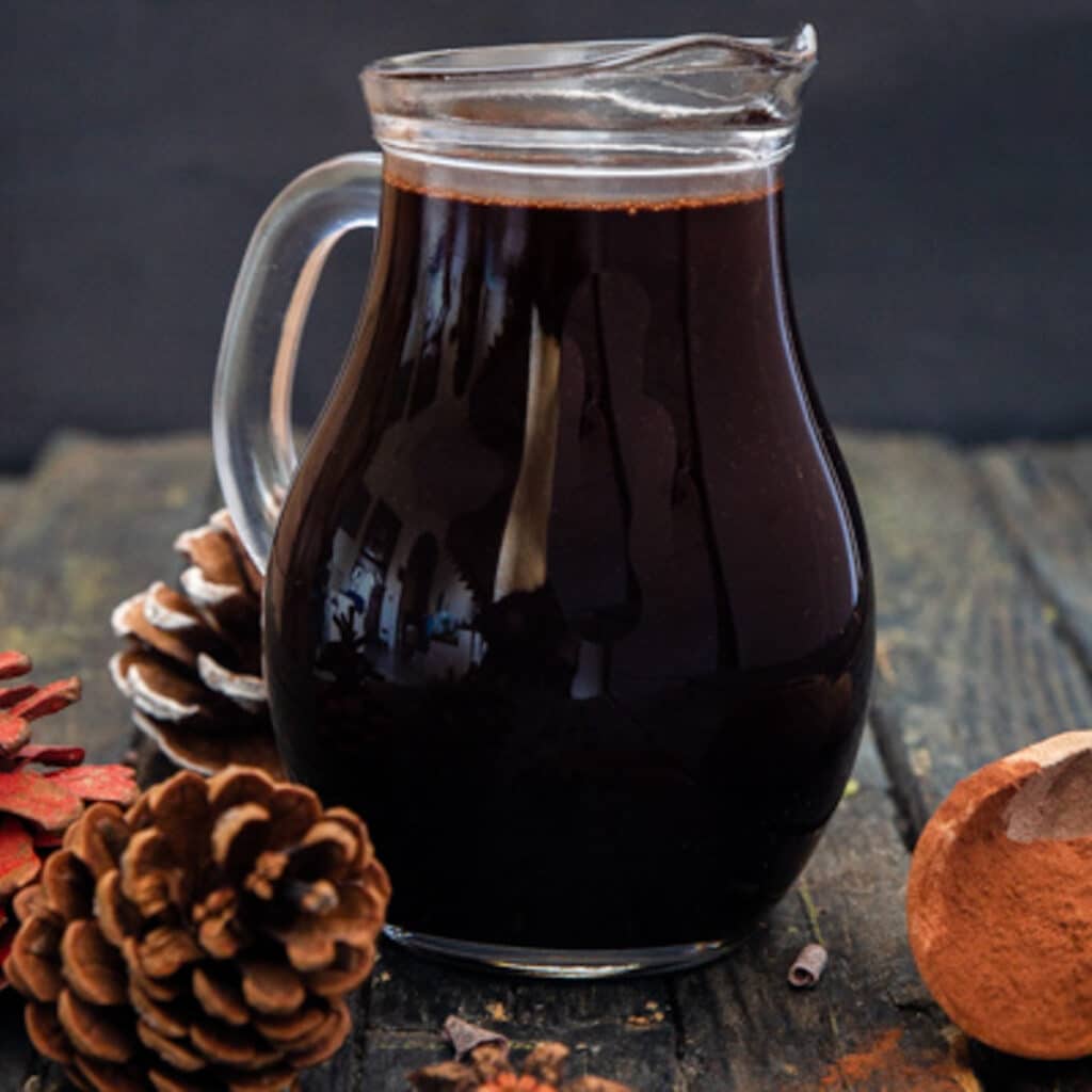 Chocolate syrup in a glass jug.