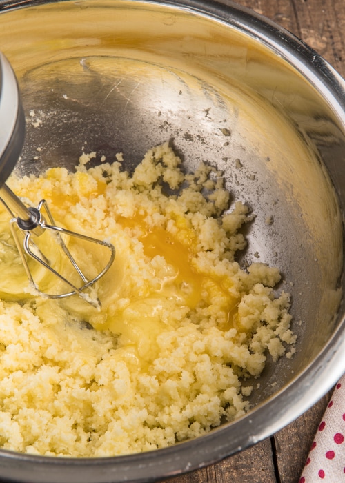 Beating the creamed ingredients and egg in a mixing bowl.