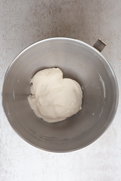 smooth dough in a silver mixing bowl